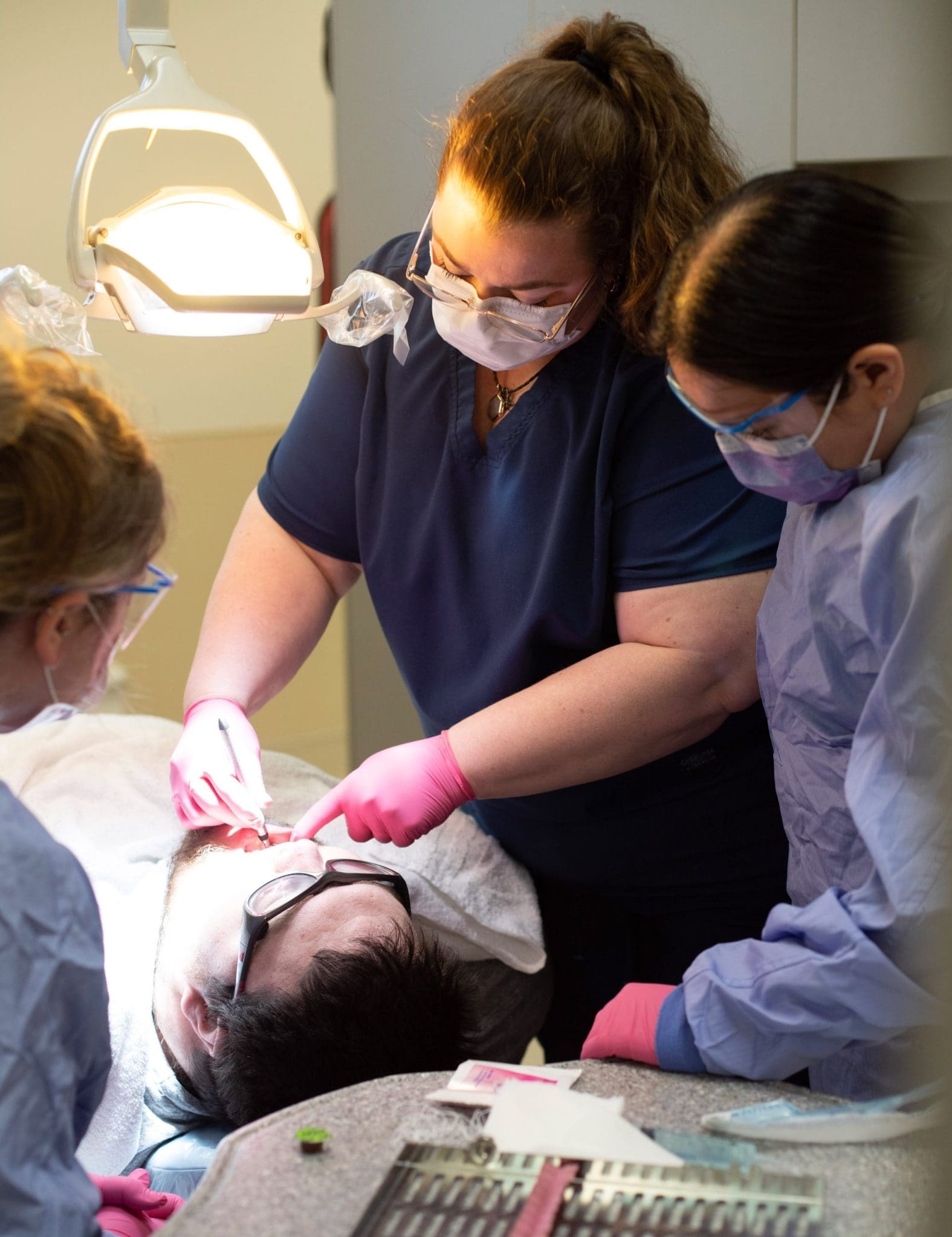 Dentist and dental students provide sensory-friendly care while treating an autistic patient during a specialized dental appointment.