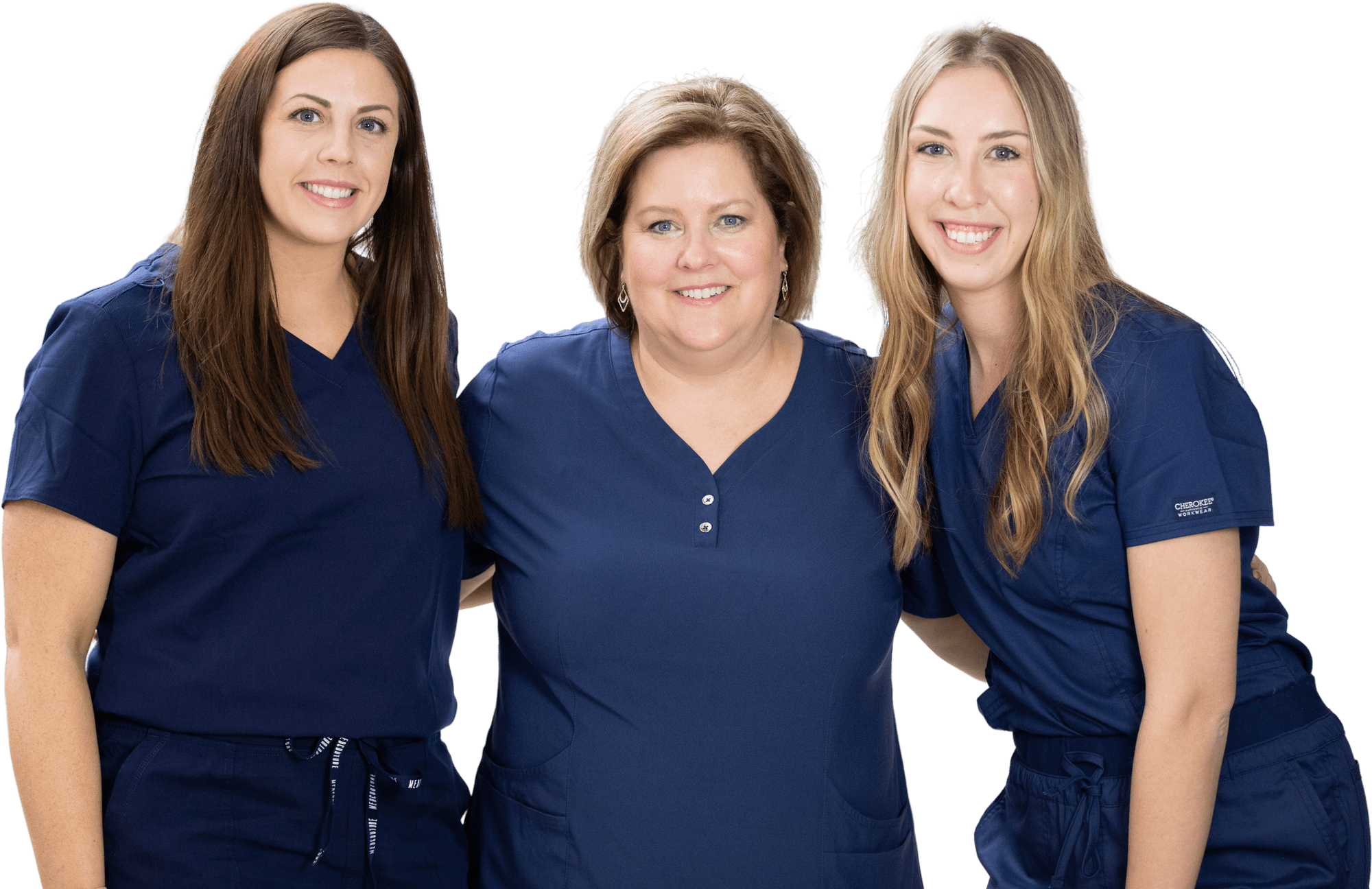 Three friendly clinic staff members smile warmly, ready to welcome patients and caregivers to our healthcare facility.
