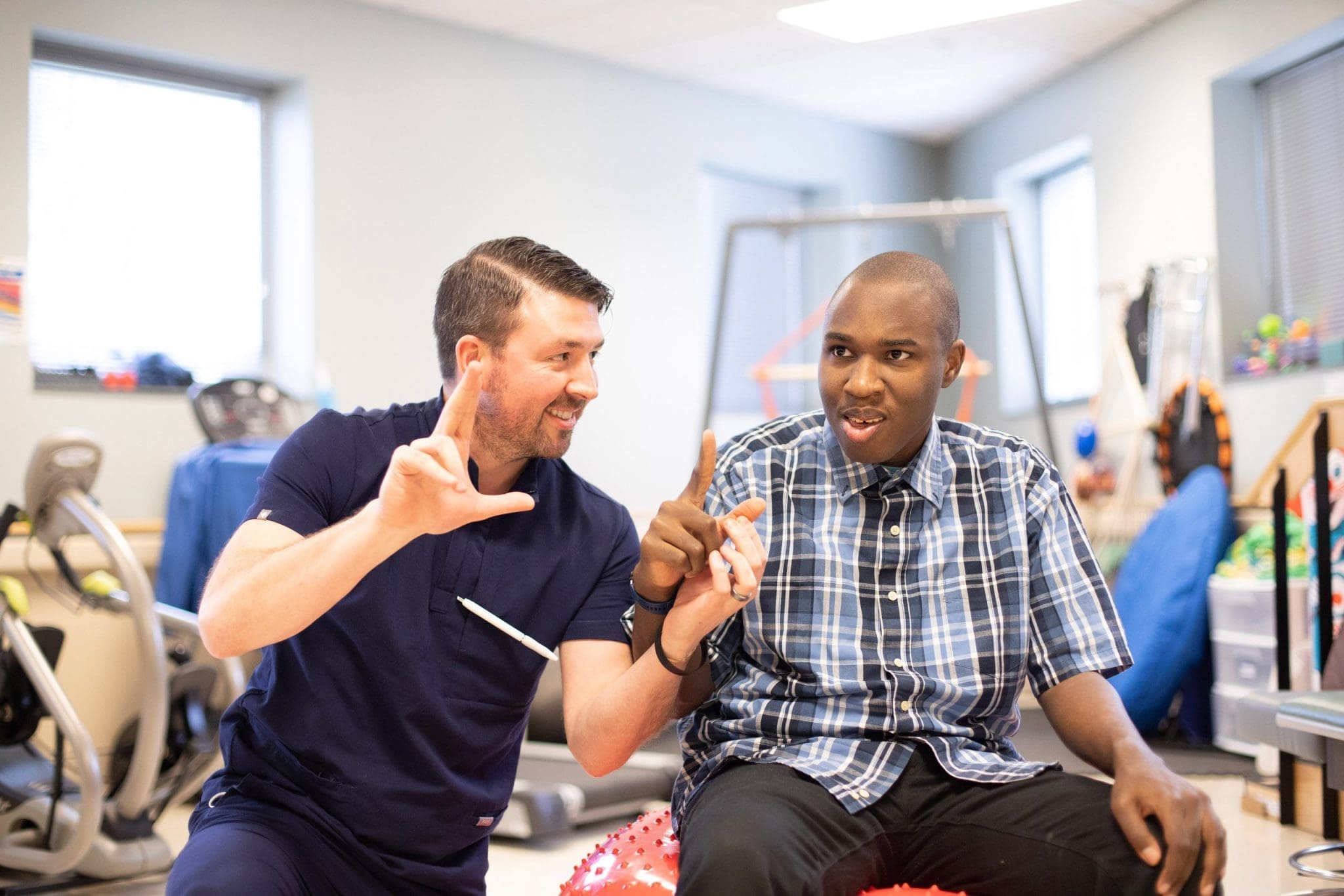 Therapist communicating with a person using hand signs in a therapy room