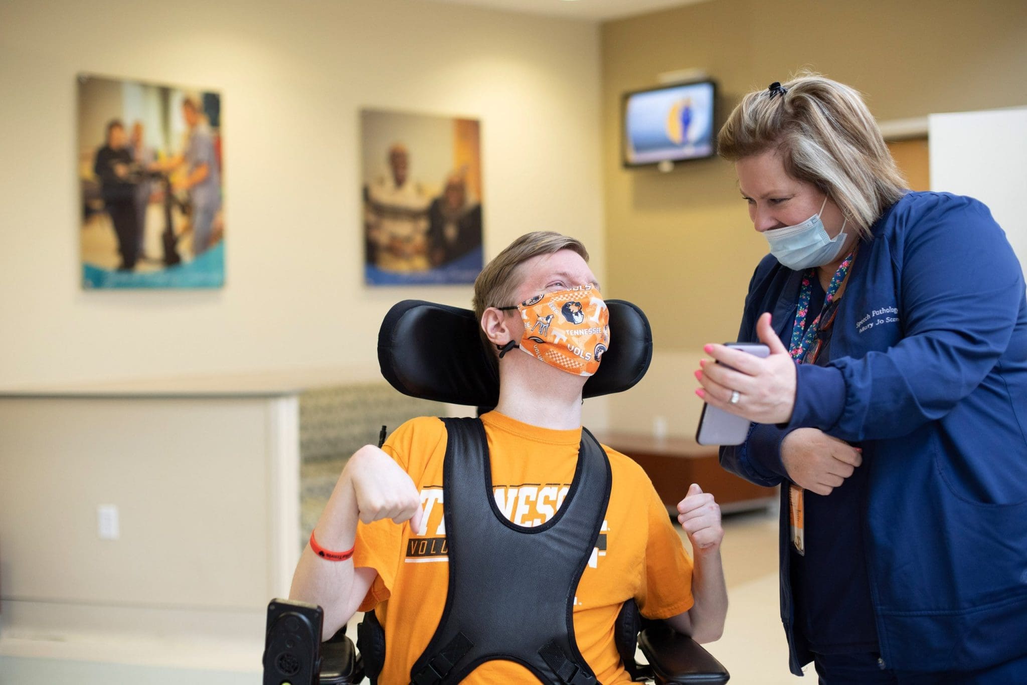 Lee Specialty Clinic provider showing a phone to a person in a wheelchair