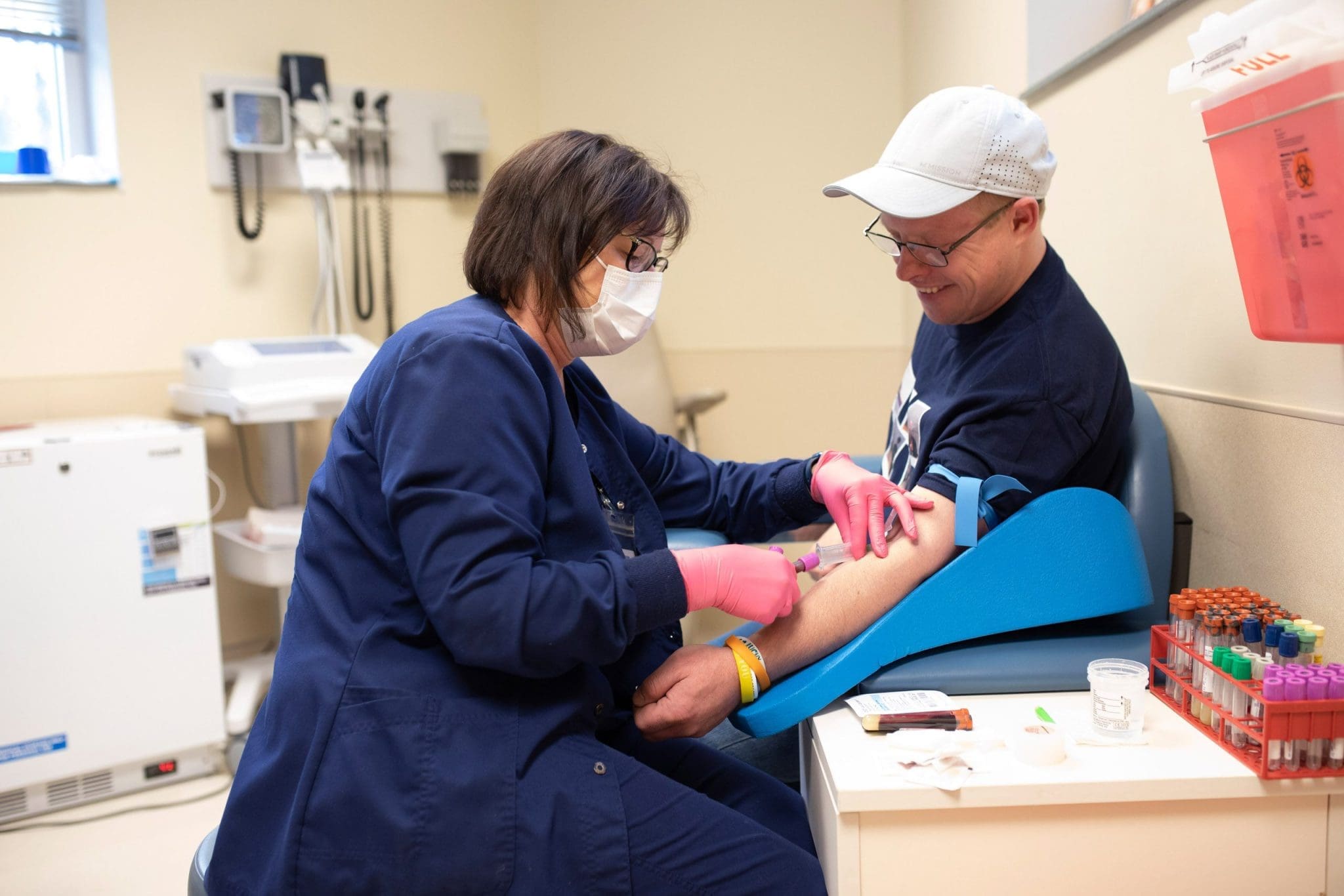 Phlebotomist draws blood from patient with intellectual and developmental disabilities (IDD) during routine medical exam.