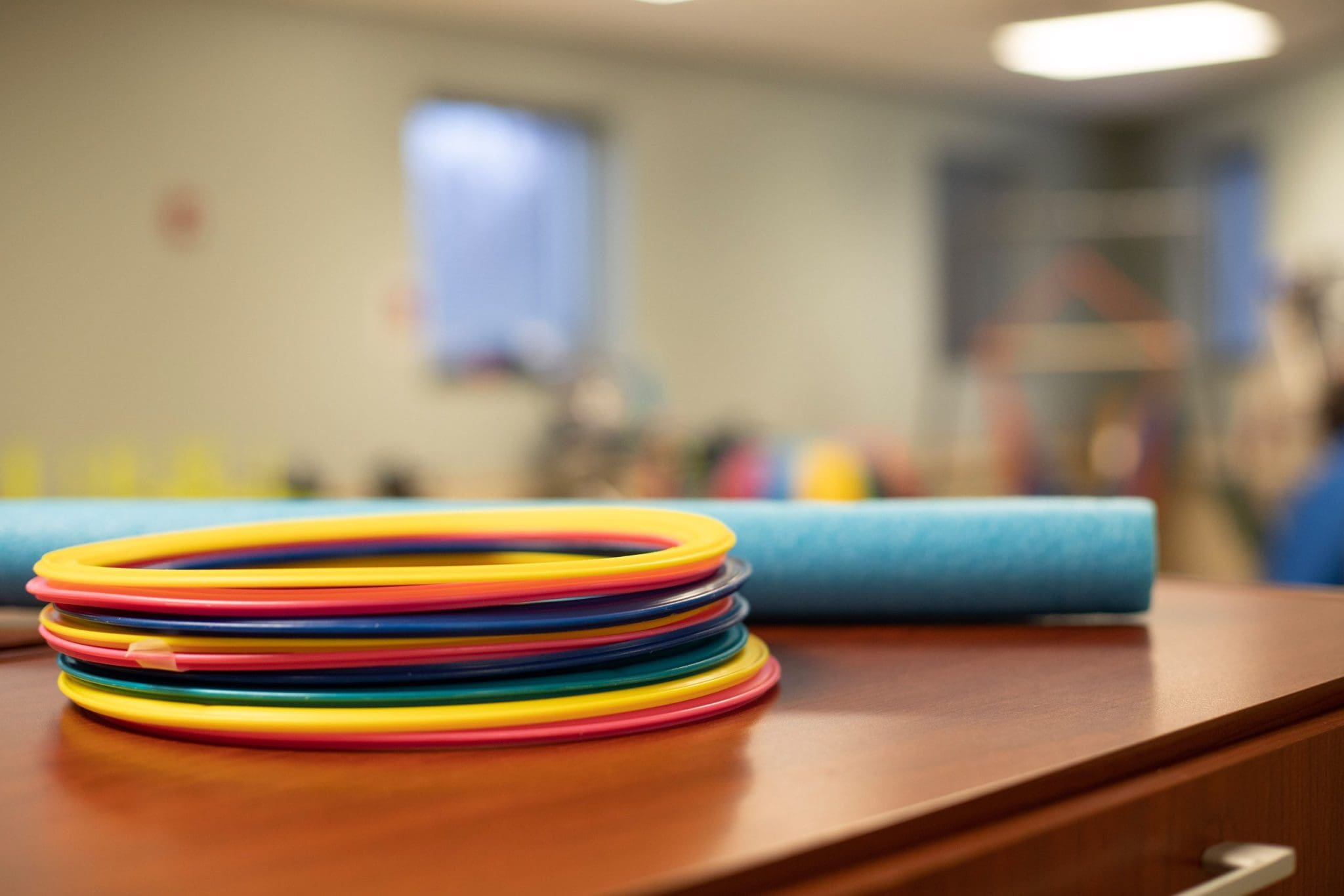 Brightly colored therapy rings and other tools used for occupational therapy, sensory integration, and fine motor skill development for individuals with intellectual and developmental disabilities (IDD).