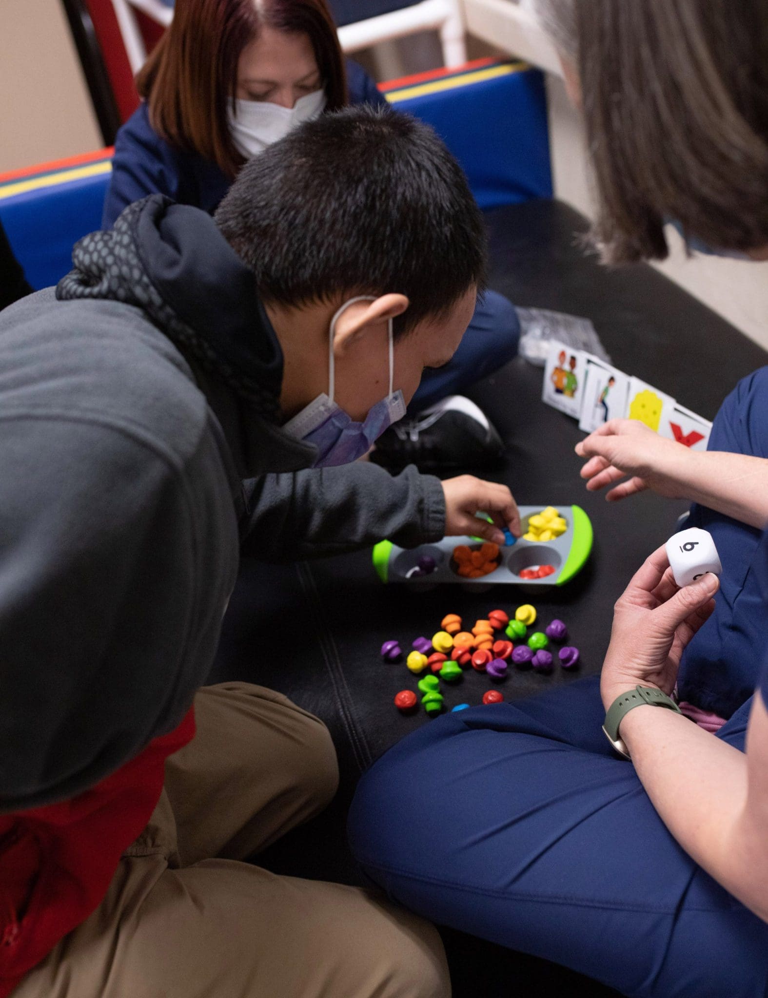 Patient with intellectual and developmental disabilities (IDD) engages with a speech therapist during a speech therapy session, using specialized tools to support communication skills for individuals with Autism Spectrum Disorder (ASD), Down Syndrome, and other neurodevelopmental conditions.