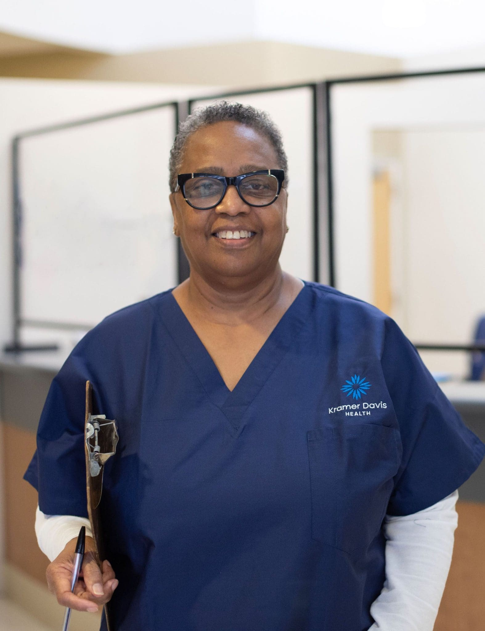 Smiling receptionist ready to greet patients and caregivers.