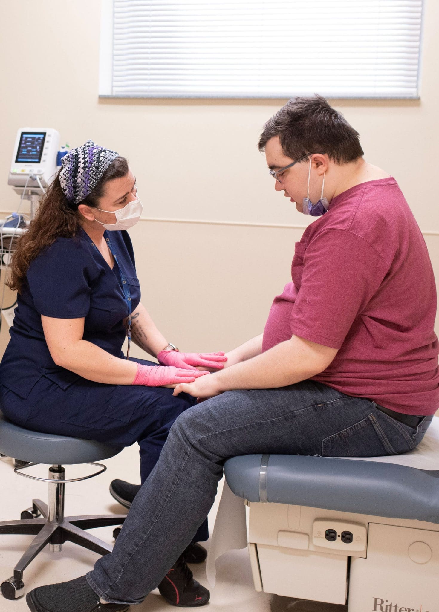 Compassionate doctor providing patient-centered care to an autistic individual during a medical appointment.